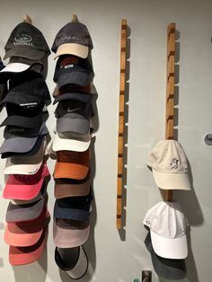 several hats are hanging up on the wall