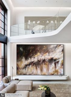 a large painting hanging on the wall in a living room