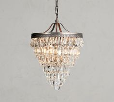 a chandelier hanging from the ceiling in a room with grey walls and flooring