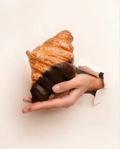 a person holding a pastry in their hand