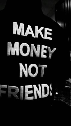 a man standing in front of a sign that says make money not friends