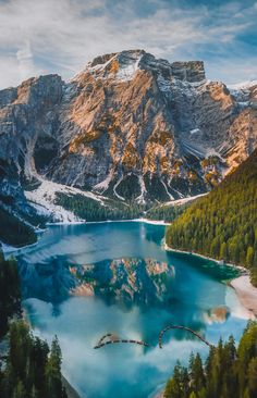 an aerial view of a mountain lake surrounded by pine trees