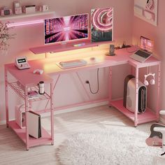 a pink desk with two computer monitors and a laptop on it, in a girls'room