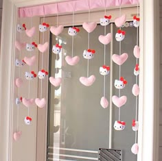 a hello kitty mobile hanging from a door with hearts attached to the front and side