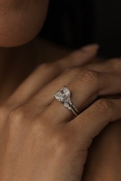 a woman's hand with a diamond ring on it