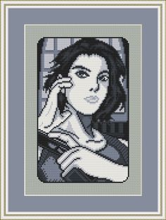 a cross stitch portrait of a woman holding a cell phone to her ear and looking at the camera