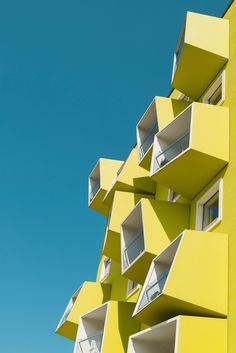 a tall yellow building with windows and balconies