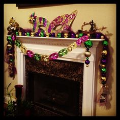 a fireplace decorated with mardi gras decorations and beads on it's mantle