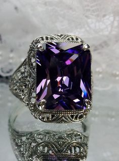 Natural Purple Amethyst or Purple Cubic Zirconia RingAutumn Design#D200 Inspired by Victorian era designs, this lovely filigree reproduction has been recreated in sterling silver. This flawless 5 carat gemstone is 12mm x10mm in size. Please choose from a VS to VVS natural purple amethyst or a flawless purple cubic zirconia gemstone. The inside of the band is etched 925 for sterling silver. Notice the intricate and detailed design of the antique silver filigree setting all the way down the band. Exquisite Rectangular Wedding Rings, Exquisite Filigree Ring With Gemstone For Formal Occasions, Exquisite Gemstone Filigree Ring For Formal Occasions, Exquisite Amethyst Wedding Ring, Exquisite Silver Amethyst Ring For Formal Occasions, Exquisite Silver Amethyst Ring For Formal Events, Exquisite Silver Amethyst Ring For Wedding, Elegant Purple Diamond Cut Ring, Classic Octagon Amethyst Ring As A Gift