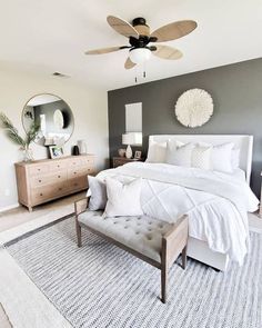 a bedroom with gray walls and white bedding