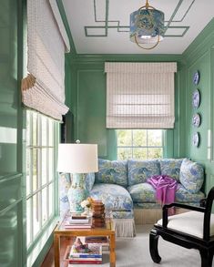 a living room filled with furniture and green walls