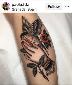 a tattoo with a bird on its arm and flowers in the other side of it