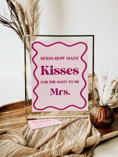 there is a sign that says guess how many kisses for the son to be mrs