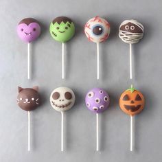 halloween cake pops are arranged on sticks with faces and eyes painted on them, all decorated in different colors