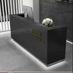 a black and white reception desk with flowers on it