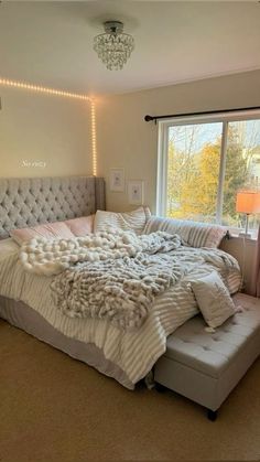 a bedroom with a large bed covered in blankets, pillows and throw pillows on it