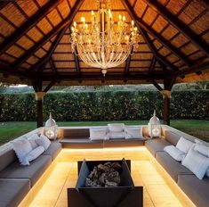 an outdoor living area with couches and chandelier