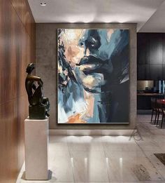 a large painting hanging on the wall next to a table and chairs in a room