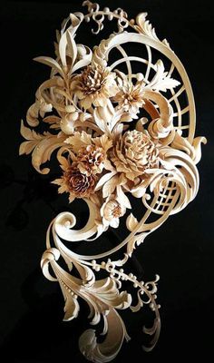 an intricately carved piece of wood with flowers on it