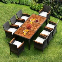 an outdoor dining table and chairs in the grass with oranges on it's side