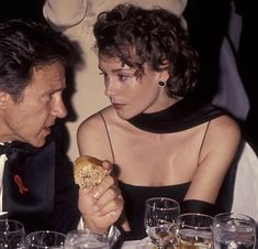 a man and woman sitting at a table eating food