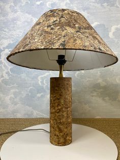 a lamp that is sitting on top of a white base with a brown and black shade