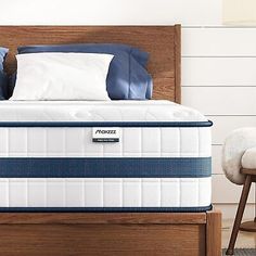 an image of a mattress in the middle of a bed with blue and white pillows