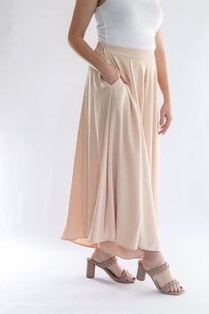 Be the talk of every room with our Keep it Glowing - Woven Wide Leg Pants! These champagne, satin pants are beyond gorgeous. They give the illusion of a skirt, but bring the comfort of pants. This item has a high waist, elastic waist band, and pockets. We love these so much because you can throw on a blouse to dress them up, or a tank to dress them down. You can wear these for any occasion and be the most stylish gal in the room! - Champagne colored woven wide leg pants - High waist - Elastic wa Beige Bottoms With Elastic Waistband, Spring Rayon Bottoms With Elastic Waistband, Versatile Lined Skirt For Summer, Solid Rayon Bottoms For Spring, Versatile Solid Color Maxi Skirt With Elastic Waistband, Elegant Solid Bottoms With Wide Waistband, Versatile Rayon Bottoms With Pockets, Versatile Bottoms With Waistband For Spring, Versatile Pleated Skirt Bottoms For Summer