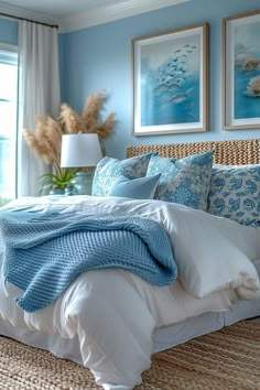 a bedroom with blue walls and white linens on the bed, along with two framed pictures