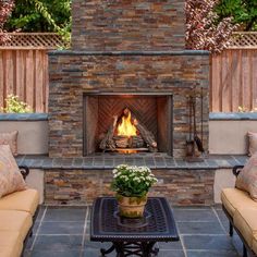 an outdoor fireplace with two couches around it