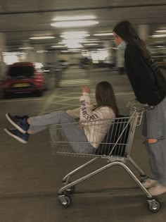 two people sitting in a shopping cart at an airport