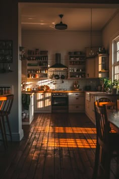 the sun is shining through the kitchen windows and onto the wood flooring in front of the stove