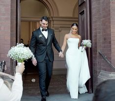 a bride and groom are walking out of the church holding hands as they exit their wedding ceremony