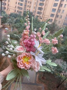 a person holding a bouquet of flowers in front of a cityscape with tall buildings