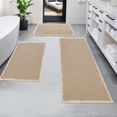 two beige rugs on the floor in a bathroom