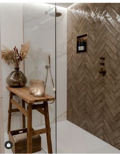 a wooden table sitting in front of a shower with a vase on top of it