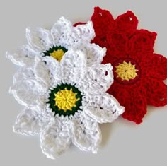 two crocheted flowers sitting next to each other