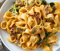 a white plate topped with pasta and meat