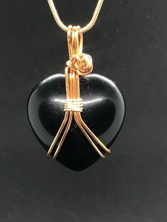 "Black Obsidian heart crystal necklace. Beautiful, dreamy new moon darkness high-quality obsidian heart shaped stone. Lovingly wrapped in your choice of high-quality tarnish resistant gold colored brass or silver colored wire.    Set with matching color 18\" or 20\" gold plated snake chain necklace.  Obsidian is volcanic glass that forms naturally. It comes from the rapid cooling of felsic lava.  Mystical Properties: Black Obsidian is believed to be a powerful tool for those seeking protection, Black Heart-shaped Gemstone Jewelry, Spiritual Black Heart-shaped Necklaces, Black Heart-shaped Jewelry For Gifts, Black Heart-shaped Jewelry Gift, Spiritual Black Heart-shaped Necklace, Black Heart Cut Necklace As A Gift, Black Heart Cut Necklace For Gift, Handmade Obsidian Necklaces As Gift, Gift Obsidian Necklaces With Natural Stones