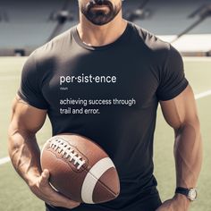 a man holding a football in his right hand and wearing a t - shirt that says persitence