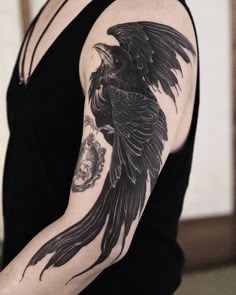 a woman with a black bird tattoo on her arm