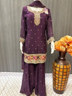 Get ready to make a striking statement in this beautiful purple sharara suit. Made with the finest satin silk material, this set is not only luxurious but also comfortable to wear. The intricate real mirror work adds a touch of elegance and sparkle, making it the perfect outfit for weddings, parties, and special occasions. The size 44 is perfect for a comfortable and flattering fit, while the vibrant purple color is sure to make you stand out in a crowd. Elevate your ethnic wardrobe with this st Traditional Purple Palazzo Set With Zari Work, Purple Silk Palazzo Set For Festivals, Festival Silk Purple Palazzo Set, Anarkali Purple Palazzo Set With Gota Work, Purple Silk Kurta With Gota Work, Elegant Purple Salwar Kameez With Gota Work, Unstitched Purple Sharara With Gota Work, Purple Anarkali Palazzo Set For Designer Wear, Purple Silk Bollywood Palazzo Set