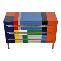 a multicolored chest of drawers with metal handles and bars on each drawer, against a white background