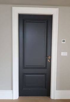 an empty room with a black door and white trim