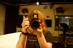 a woman taking a selfie in front of a mirror while holding a camera up to her face