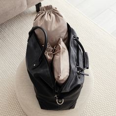 a black bag sitting on top of a white ottoman