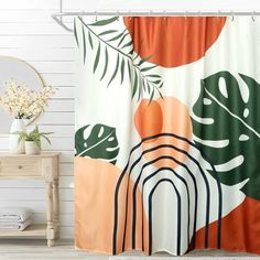 an orange and green shower curtain hanging on a white wall next to a wooden chair