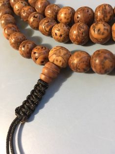 "Bodhi seed mala necklace made of 108 12mm beads with a Bodhi seed guru bead and an adjustable knot that allows you to change the length and tightness of the beads. Bodhi seeds are usually not polished so they are a solid color with small ridges or veins. Bodhi in Sanskrit translates to \"enlightened\" or \"awakened,\" therefore the Bodhi seed means \"enlightened seed.\" Bodhi is also a term in Buddhism to reflect a Buddha's understanding of the true nature of things. Many Buddhist wear the Bodh Round Beaded Bracelets For Meditation And Festivals, Adjustable Necklace With Oval Beads For Meditation, 108 Spiritual Beads For Meditation, Beaded Bracelets With Round Beads For Meditation And Festivals, Spiritual Brown Beaded Bracelets, Beaded Bracelets For Meditation And Festivals, Spiritual Round Beaded Bracelets For Meditation, Spiritual Beaded Bracelets For Meditation, Brown Beaded Necklaces For Meditation And Festivals