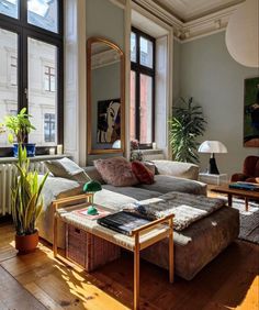 a living room filled with furniture and lots of window sill space next to a large mirror