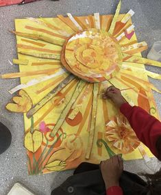 a child is making a paper sun craft